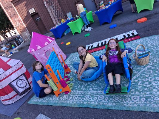 Two Children Standing Behind a Plant Box